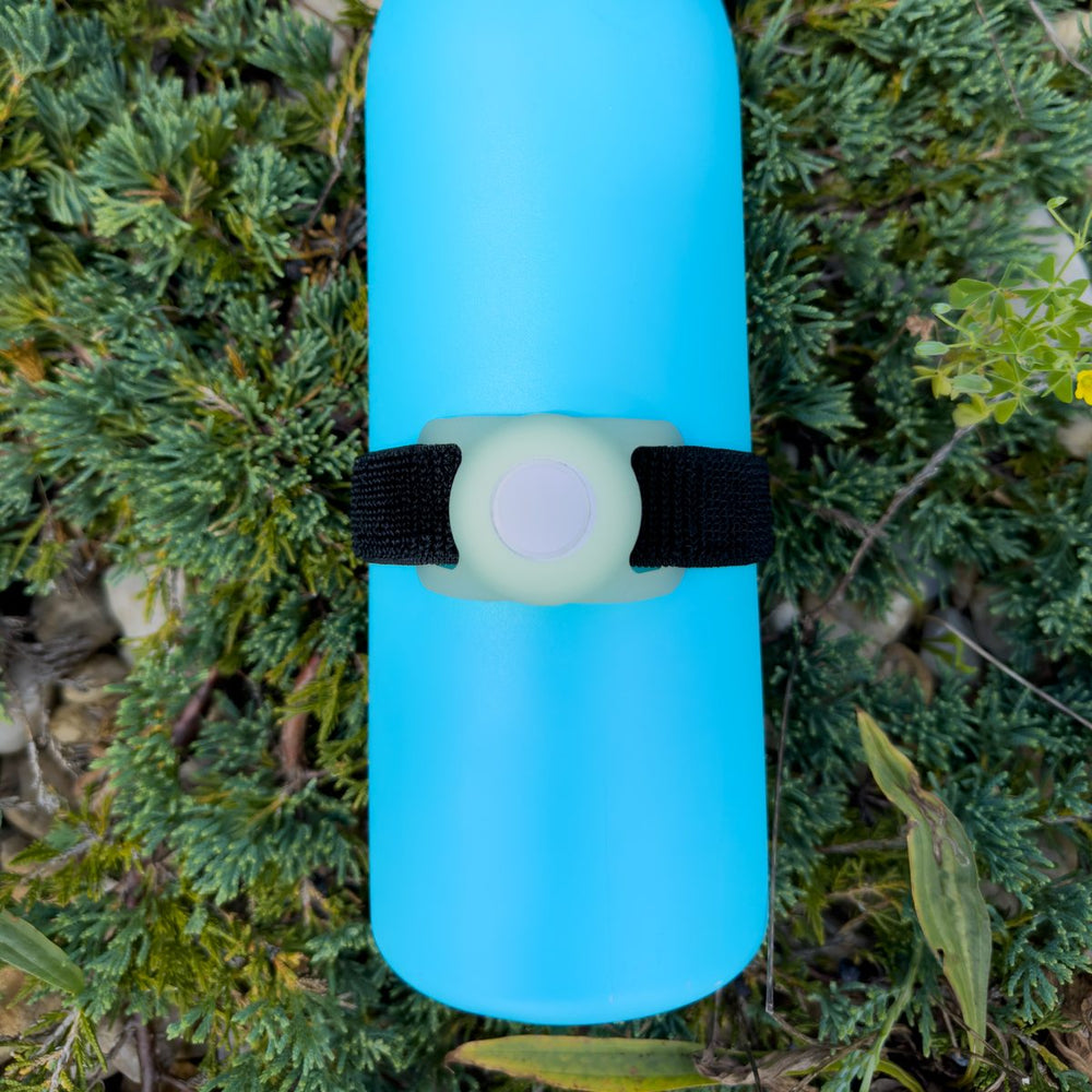 Glow in the Dark Bottle Beacon strap holding an Apple AirTag on a light blue Owala bottle